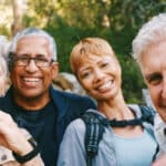 nature, selfie and senior friends hiking together in a forest while on an outdoor adventure. happy, smile and portrait of a group of elderly people trekking in woods for wellness, health and exercise